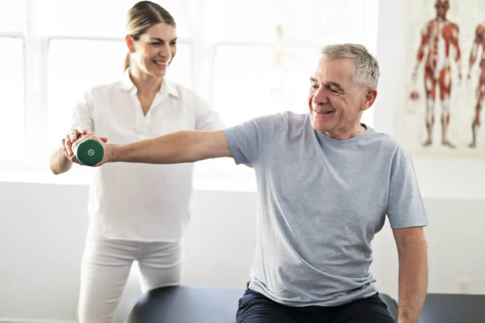 Persona mayor realizando ejercicios con su fisioterapeuta