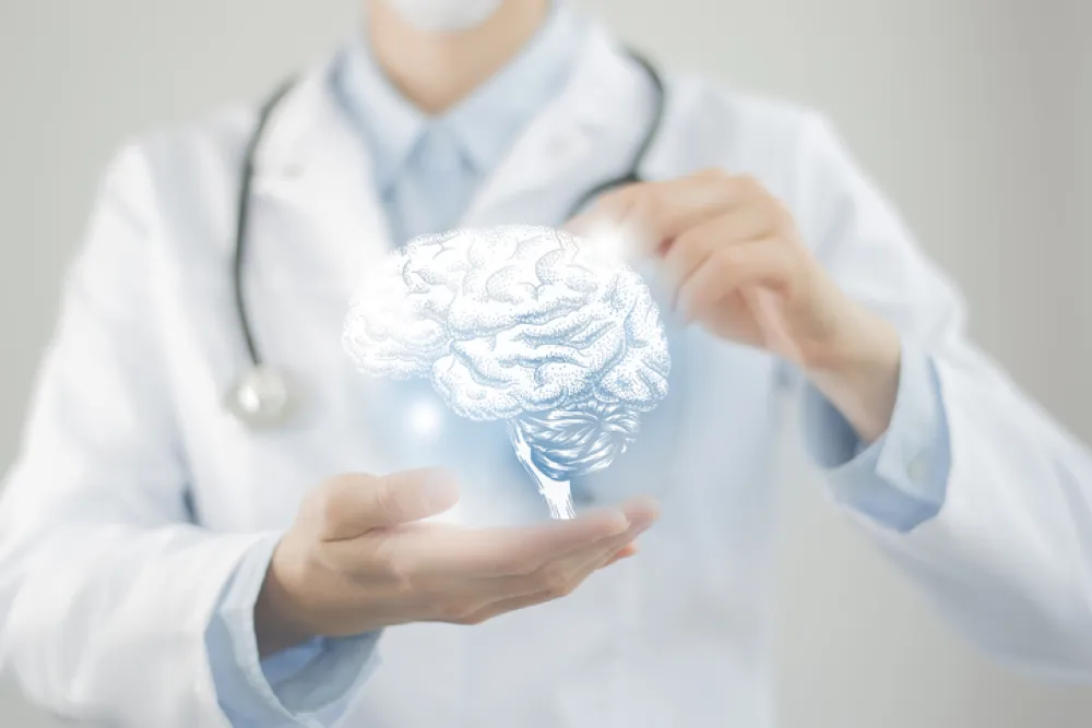 Foto de un médico sosteniendo entre dos manos un dibujo virtual de un cerebro